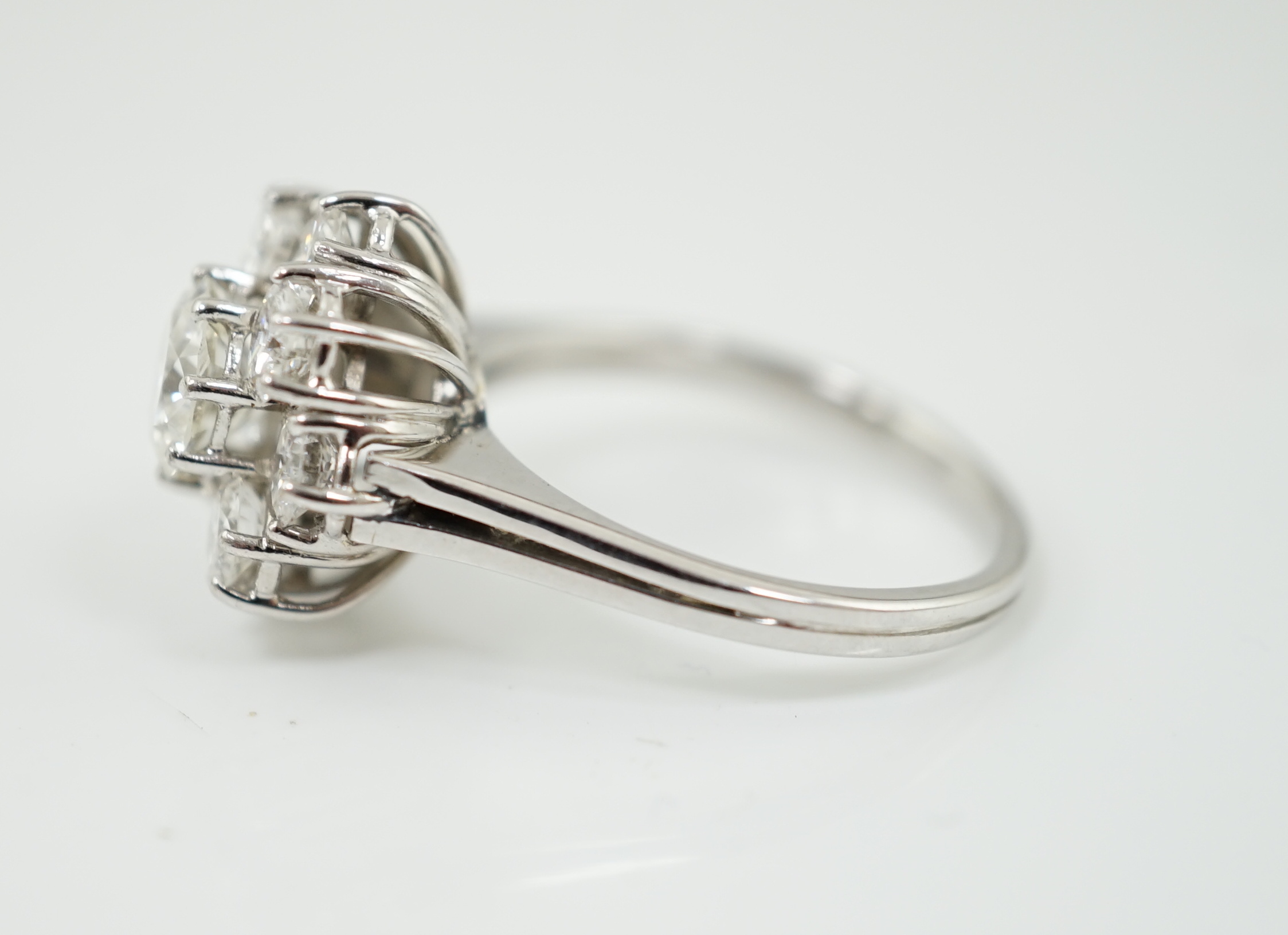 A modern 18ct white gold and round brilliant cut nine stone diamond set cluster ring